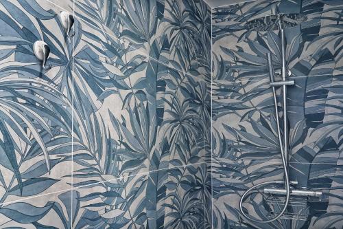 a bathroom with a mural of plants on the wall at Lo Scoglio della Formica B&B in Capo dʼOrlando