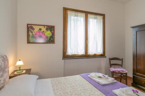 ボルゲリにあるOsteria Vecchia 6のベッドルーム1室(ベッド1台、窓、椅子付)