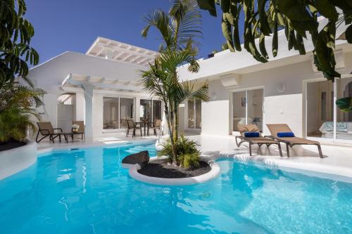 een villa met een zwembad en een huis bij Bahiazul Resort Fuerteventura in Corralejo