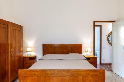 ein Schlafzimmer mit einem Holzbett und zwei Nachttischen in der Unterkunft Casa Lido in Seravezza