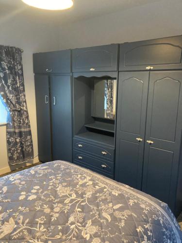 a bedroom with a bed and a blue cabinet at Clinton’s cottage in Leitrim