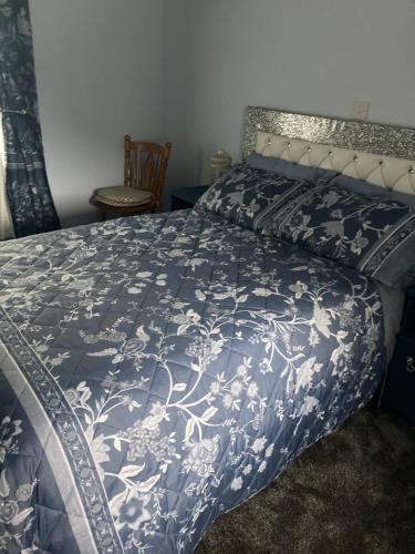 a bedroom with a bed with a blue and white bedspread at Clinton’s cottage in Leitrim