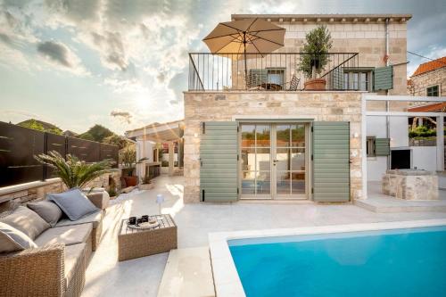 une villa avec une piscine et une maison dans l'établissement Villa Mara- Casa Rustica, à Korčula