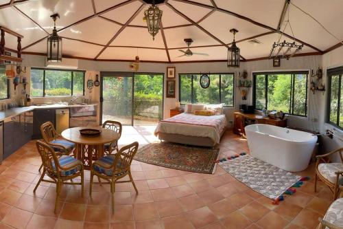 een slaapkamer met een bad, een bed en een tafel bij Evermoore Retreat Castle by the river in Gleniffer