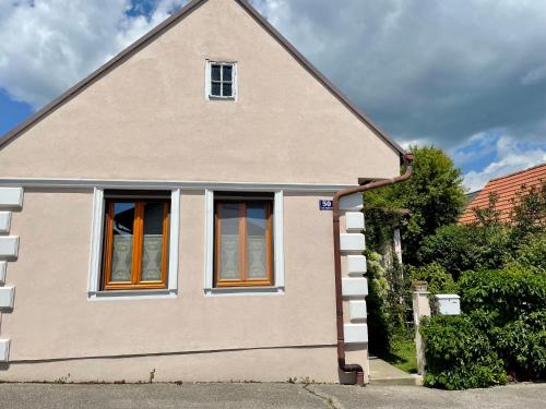 Una casa con dos ventanas en el lateral. en Landhaus mit Garten en Neutal