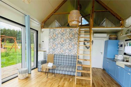 a tiny house with a loft bed and a couch at PAPIERÓWKA in Dźwierzuty
