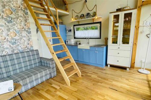 a living room with a staircase and a kitchen at PAPIERÓWKA in Dźwierzuty