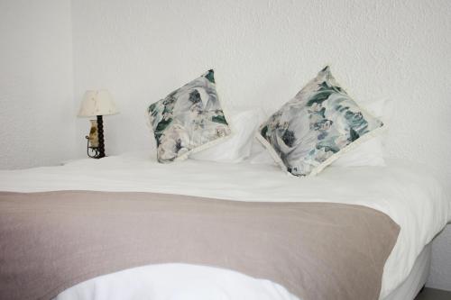 1 dormitorio con 1 cama con 2 almohadas en Eucalyptus Cottage en Ciudad del Cabo