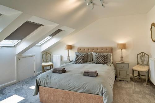 a bedroom with a large bed and two chairs at Finest Retreats - Brunels Reach in Saltash