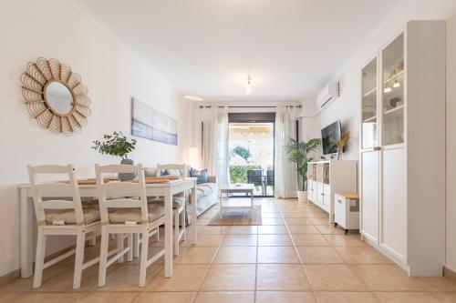 cocina y comedor con mesa y sillas en Apartamento Planta Baja Coto Sancti Petri Playa de la Barrosa, en Chiclana de la Frontera