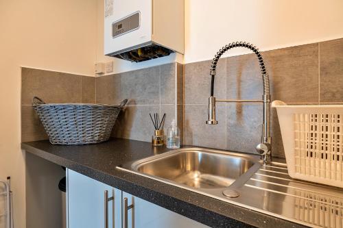 a kitchen with a stainless steel sink and a microwave at Finest Retreats - Brunels Reach in Saltash