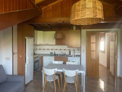 - une cuisine avec une table, des chaises et un canapé dans l'établissement Maravilloso apartamento De la Santina 2B con vistas, à Avilés