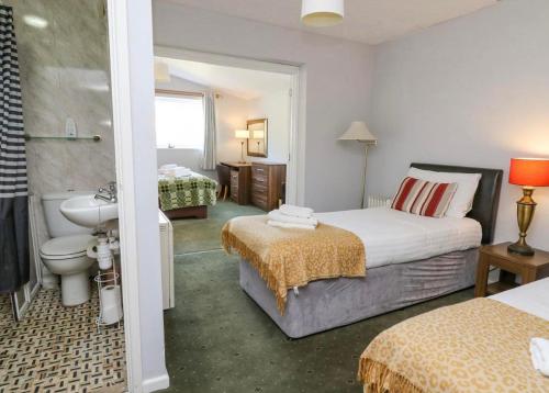 アベリストウィスにあるAberceiro Bungalowのベッド2台とバスルームが備わるホテルルームです。