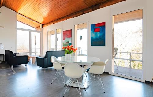 ein Esszimmer mit einem weißen Tisch und Stühlen in der Unterkunft Casa AmaRe - einzeln stehendes Haus mit spektakulärer Aussicht in Gambarogno