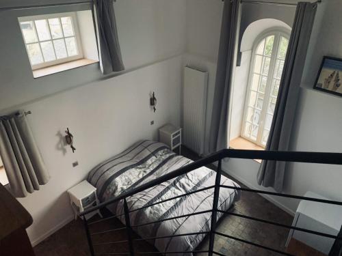 une chambre avec un lit et deux fenêtres dans l'établissement L'Annexe, à Génainville