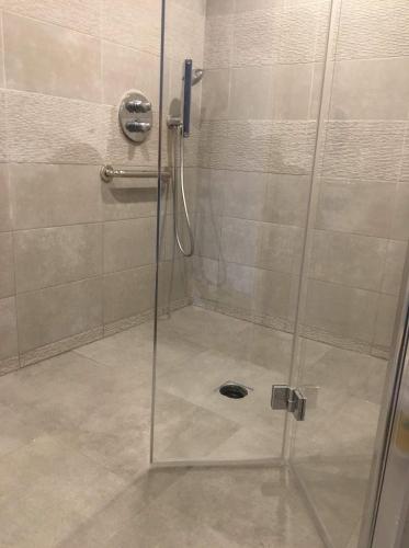 eine Dusche mit Glastür im Bad in der Unterkunft L'Annexe 