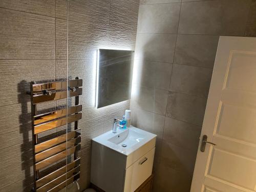ein Bad mit einem Waschbecken und einem Spiegel in der Unterkunft The View, Luxury studio in Curbar