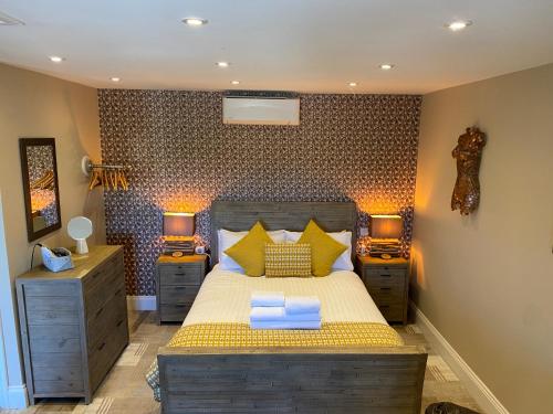a bedroom with a bed with two night stands and two lamps at The View, Luxury studio in Curbar