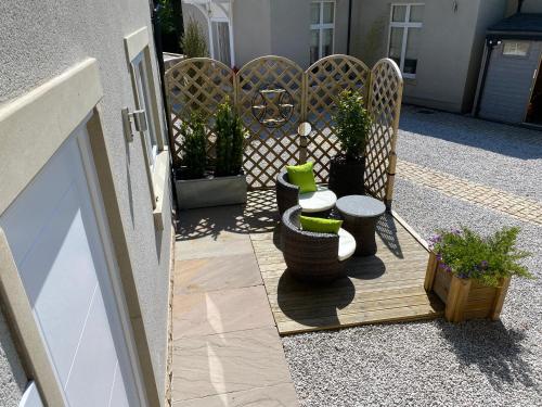 a patio with two tables and chairs and potted plants at The View, Luxury studio in Curbar