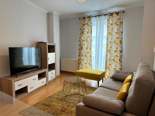a living room with a couch and a flat screen tv at Apartamento Ría de Arousa in Boiro