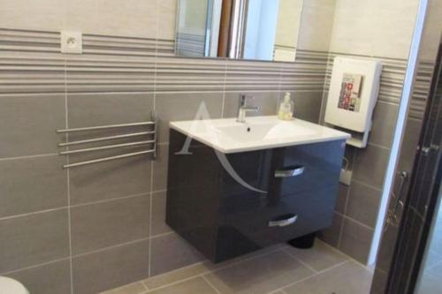un baño con lavabo y espejo en Appartement à 5mn de la plage en RdC, en Narbonne-Plage