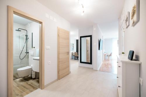 - une salle de bains blanche avec une porte menant à un couloir dans l'établissement Bridge Comfort Apartment, à Zadar