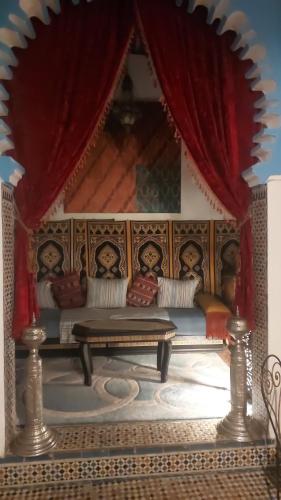 sala de estar con sofá y mesa en Riad Khmisa en Tetuán