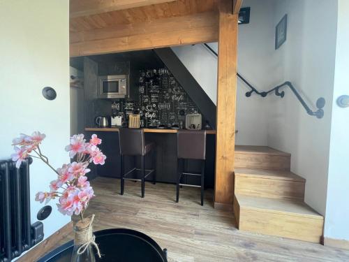 a living room with a staircase and a bar at La Maison du Pere Pilon avec petit dejeuner in Auvers-sur-Oise