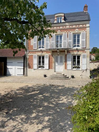 a large brick house with a large driveway at La Maison du Pere Pilon avec petit dejeuner in Auvers-sur-Oise