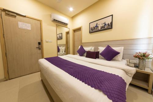 a bedroom with a large bed with purple pillows at Sagar Hotel JUST 5 MIN FROM GOLDEN TEMPLE in Amritsar