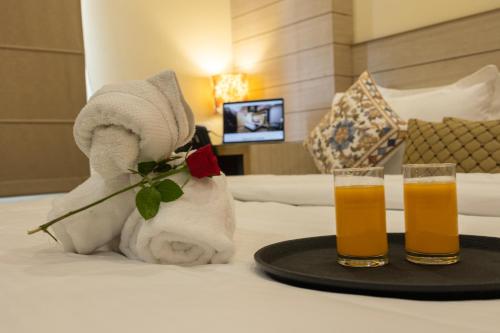 a couple of glasses of beer on a bed at Sagar Hotel JUST 5 MIN FROM GOLDEN TEMPLE in Amritsar