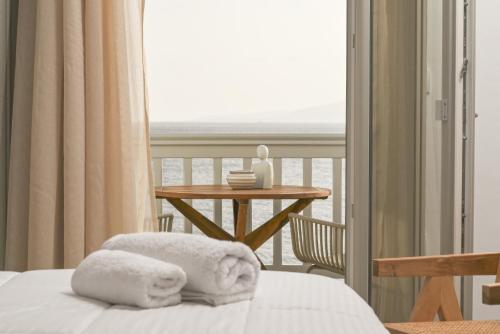 a room with a bed and a balcony with a table at Castello studios in Agia Anna Naxos