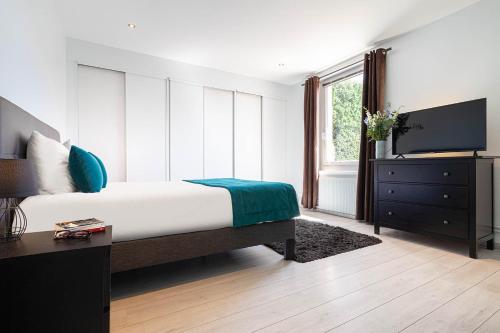 ein Schlafzimmer mit einem Bett und einem TV in der Unterkunft Contact Hôtels Les Pierres Dorées in Ambérieux d'Azergues