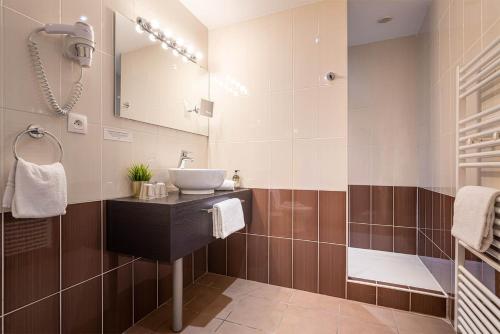 W łazience znajduje się umywalka i lustro. w obiekcie Contact Hôtels Les Pierres Dorées w mieście Ambérieux d'Azergues