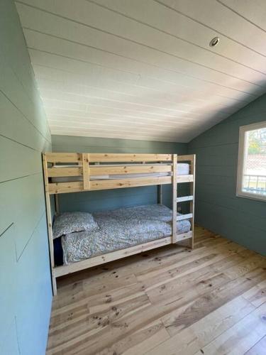 une chambre avec deux lits superposés dans une pièce dans l'établissement Charmante maison aux Abatilles-piscine-8 pers, à Arcachon