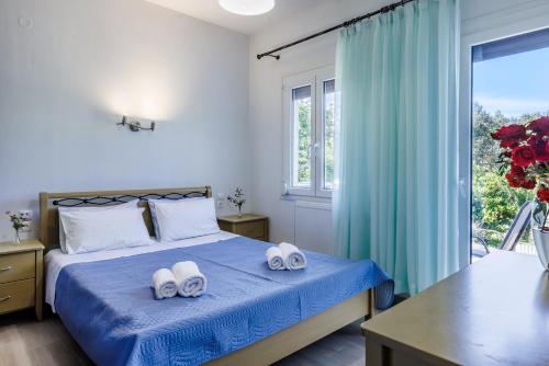 a bedroom with a bed with two towels on it at The Green Yard Apartment in Skopelos Town