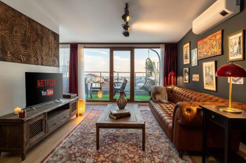 a living room with a brown leather couch and a television at Monnas Suite in Istanbul