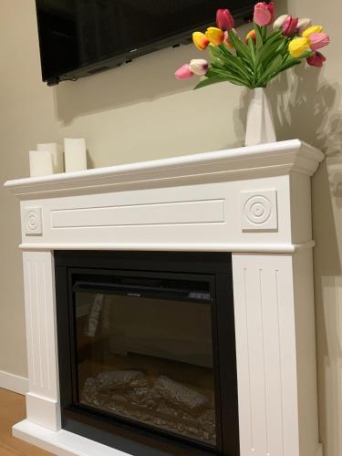 a fireplace with a white mantle with a vase of flowers at This is my happy place in Leggiuno