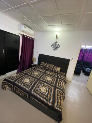 a bedroom with a bed in a room with purple curtains at Harmonious haven services in Ibadan