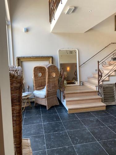 a hallway with stairs and a mirror and a chair at B&B Jadis et Naguère in Noduwez