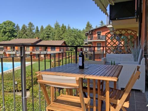 a bottle of wine sitting on a wooden table on a balcony at This is my happy place in Leggiuno