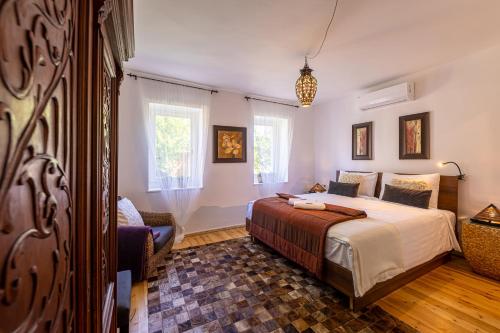 um quarto com uma cama e uma cadeira em Butik Design Nádas em Abádszalók