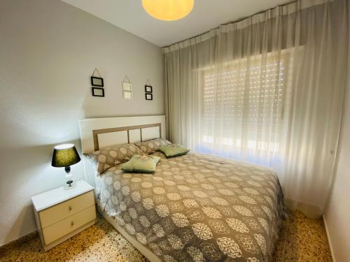 Schlafzimmer mit einem Bett und einem Fenster in der Unterkunft Casa Don Juan in Santa Pola