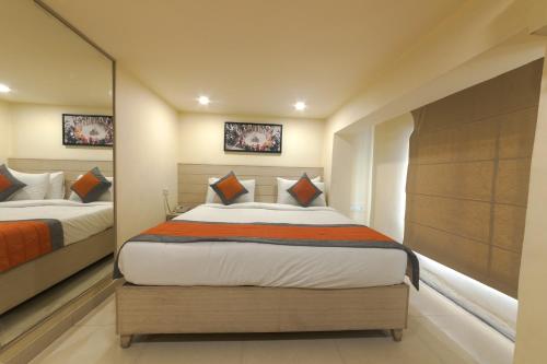 a bedroom with two beds and a mirror at Sagar Hotel JUST 5 MIN FROM GOLDEN TEMPLE in Amritsar