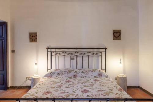 1 cama en una habitación blanca con 2 lámparas en Dolce far niente, en San Romano