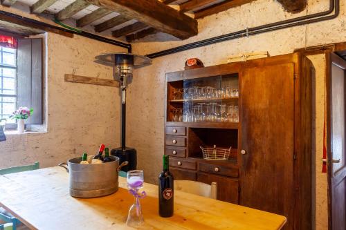 una cocina con una mesa de madera y una botella de vino en Dolce far niente, en San Romano