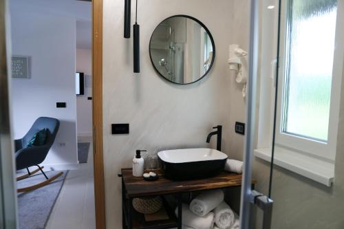 a bathroom with a sink and a mirror at Flora Studio Apartments in Korenica