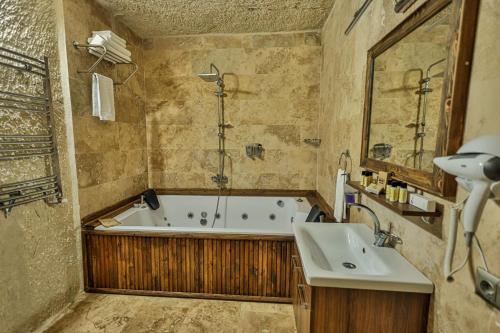 a bathroom with a bath tub and a sink at CaveAdocia in Nevsehir