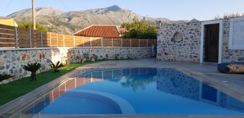 a swimming pool in a backyard with mountains in the background at Double Bee Villa with private pool in Agios Konstantinos