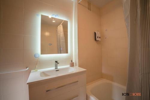 a bathroom with a sink and a mirror and a tub at Roth House in Ezcaray